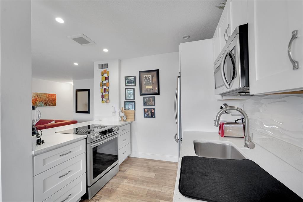 1201 South Riverside Drive, Unit 204 Pompano Beach, FL 33062 - Photo 14 of 48 a kitchen with stainless steel appliances a sink stove and cabinets