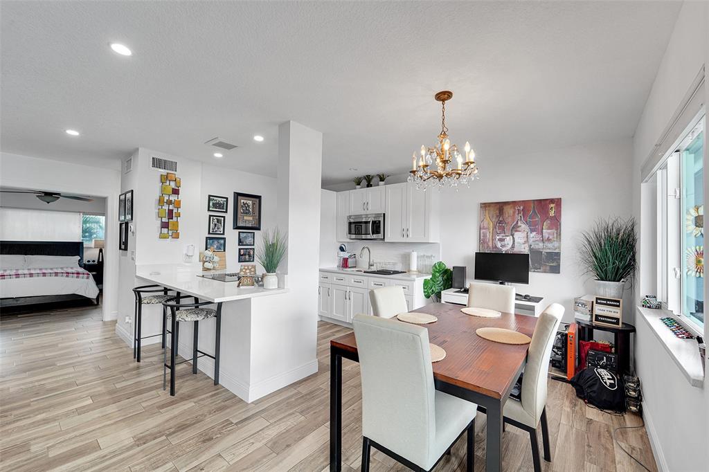 1201 South Riverside Drive, Unit 204 Pompano Beach, FL 33062 - Photo 17 of 48 a view of a dining room with furniture wooden floor and chandelier