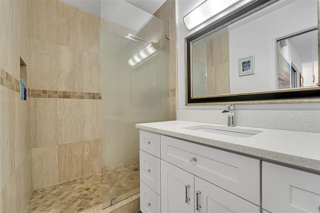 1201 South Riverside Drive, Unit 204 Pompano Beach, FL 33062 - Photo 23 of 48 a bathroom with a granite countertop sink a mirror and shower