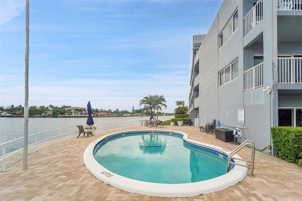 1201 South Riverside Drive, Unit 204 Pompano Beach, FL 33062 - Photo 26 of 48 a view of a swimming pool with an outdoor seating