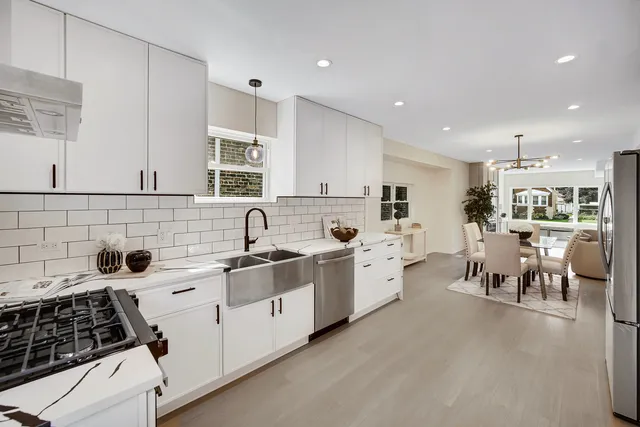 a kitchen with white cabinets and stainless steel appliances