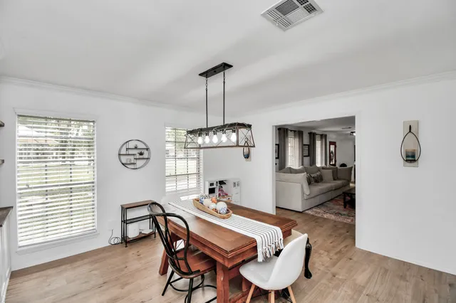 a dining room with furniture a chandelier and wooden floor