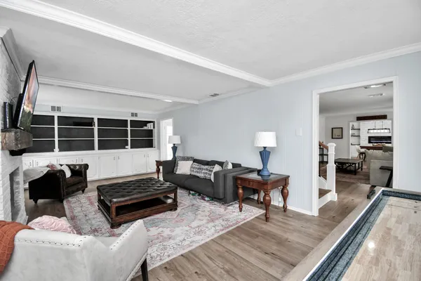 a kitchen with stainless steel appliances granite countertop a refrigerator a stove and a sink with wooden floor