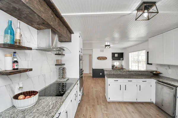 a kitchen with granite countertop a refrigerator sink and stove