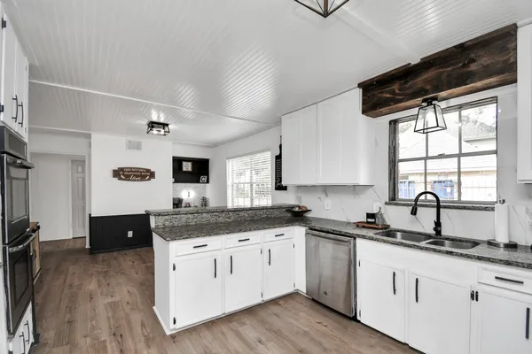 a large kitchen with stainless steel appliances granite countertop a refrigerator and a sink