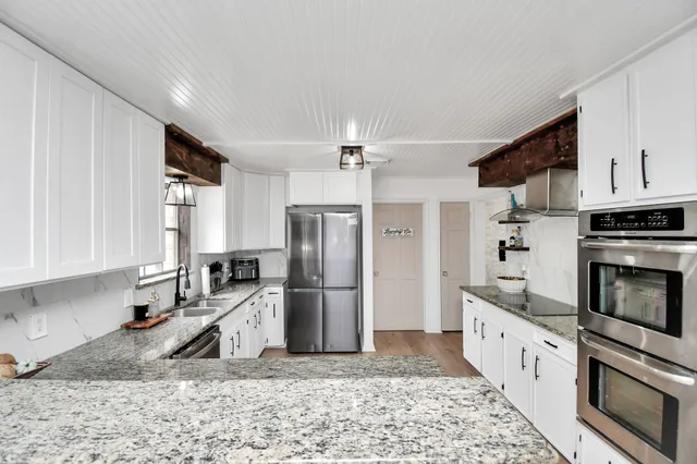 a kitchen with granite countertop a refrigerator sink and stove