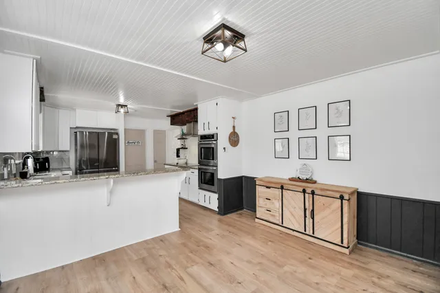 a large kitchen with stainless steel appliances granite countertop a refrigerator and a sink