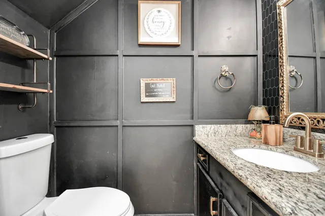 a bathroom with a granite countertop sink toilet and shower