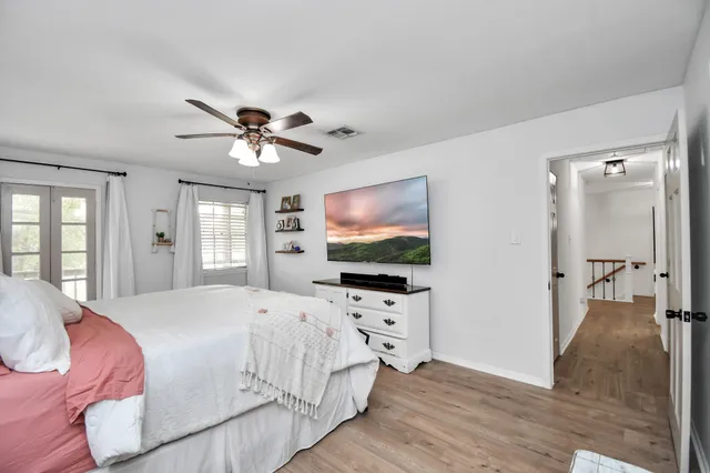 a spacious bedroom with a bed and a flat screen tv
