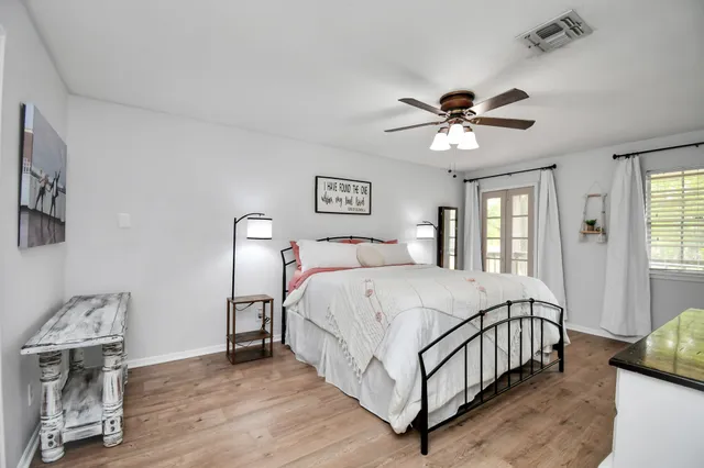 a bedroom with a bed chandelier and a window