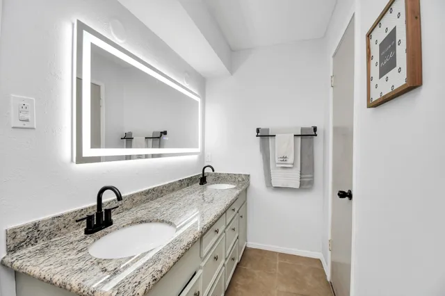 a bathroom with a granite countertop sink and a mirror