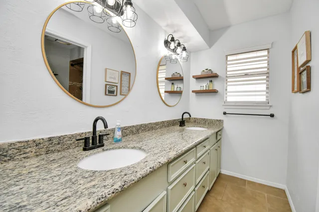 a bathroom with a granite countertop sink and a mirror