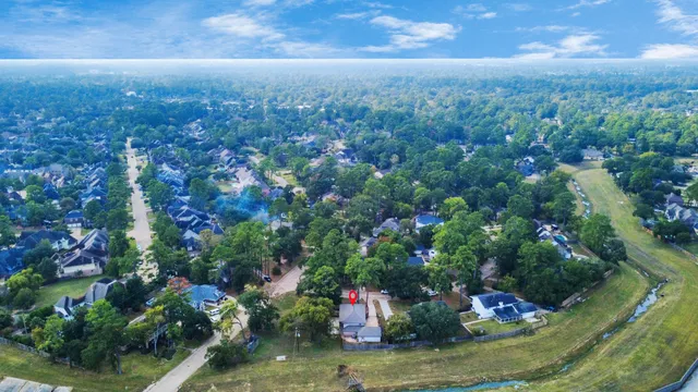 an aerial view of residential houses with outdoor space and trees