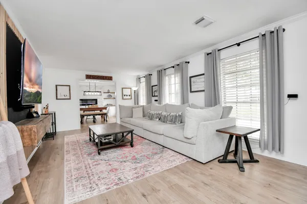 a living room with furniture and a wooden floor