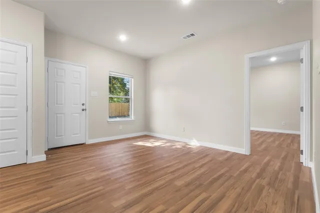 a kitchen with stainless steel appliances granite countertop white cabinets a sink a stove a refrigerator and a microwave