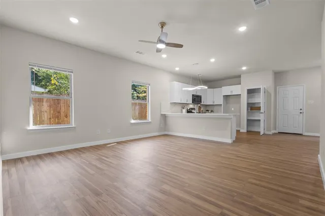 a view of kitchen with kitchen island a sink wooden floor and a refrigerator