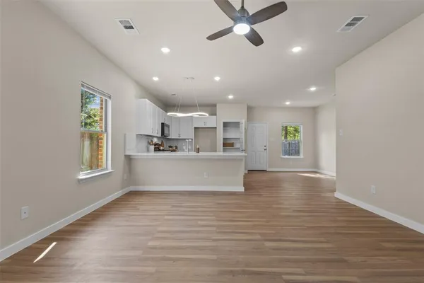 a view of a kitchen with a sink dishwasher cabinets and a large kitchen counter space