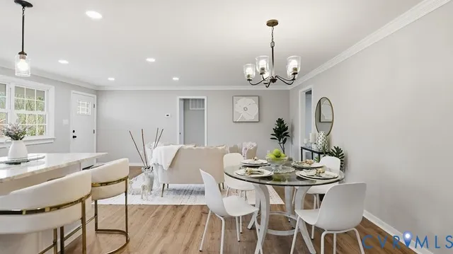 a view of a dining room with furniture a chandelier and wooden floor
