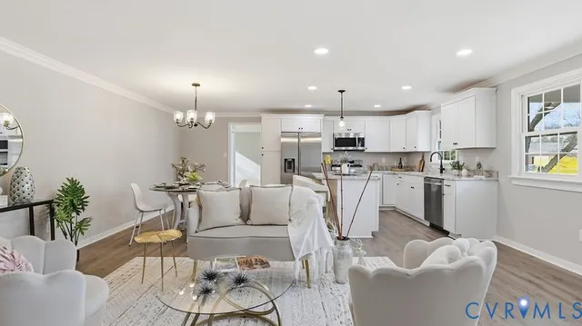 a living room with furniture kitchen and a chandelier