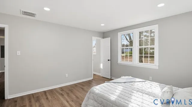 a spacious bedroom with a bed and a window