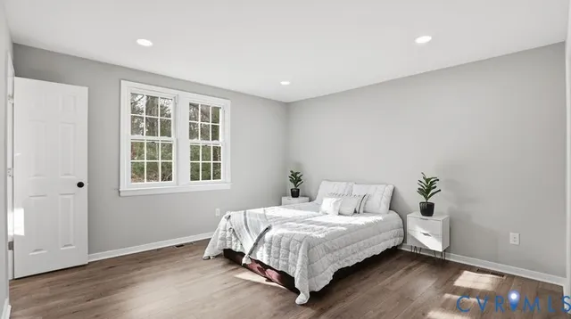 a bedroom with a bed and wooden floor