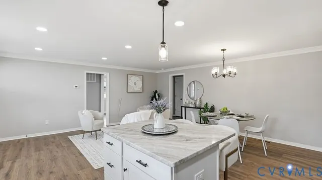 a view of a dining room and livingroom with furniture wooden floor a chandelier