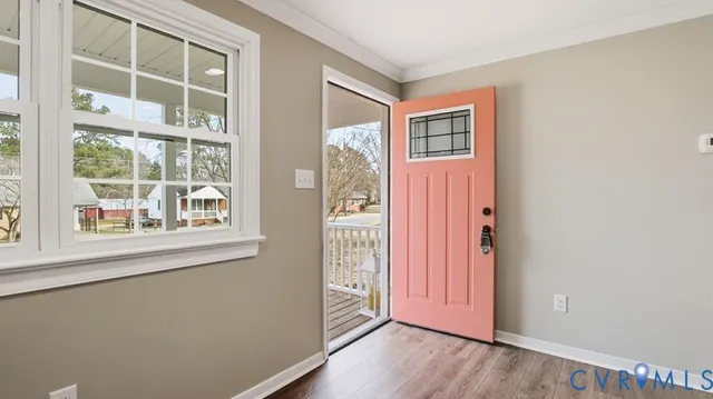 an entryway with wooden floor and windows