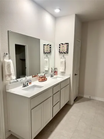 a bathroom with double sink and a mirror