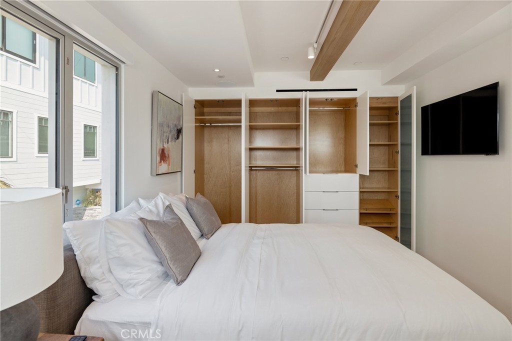 4310 Ocean Drive Manhattan Beach, CA 90266 - Photo 36 of 54 a bedroom with a bed and a flat screen tv
