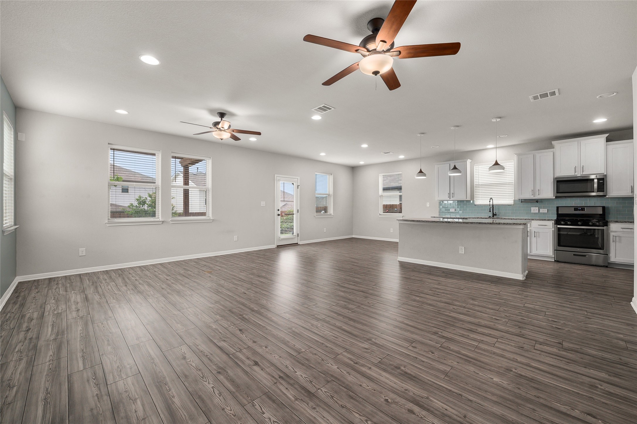 101 Lambert Street Leander, TX 78641 - Photo 5 of 33 An open-concept living space with sleek flooring and a contemporary kitchen offers a welcoming flow.
