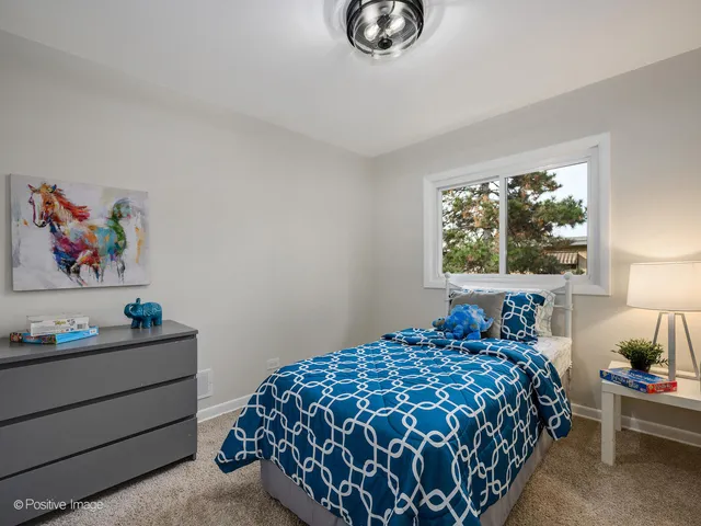 a bedroom with a bed and a painting on the wall