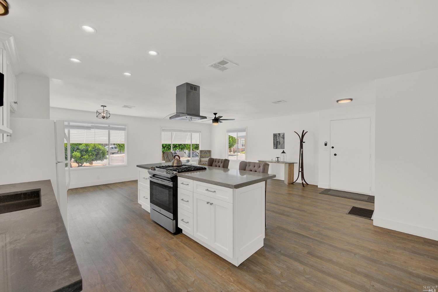 a kitchen with stainless steel appliances a sink stove and wooden floor
