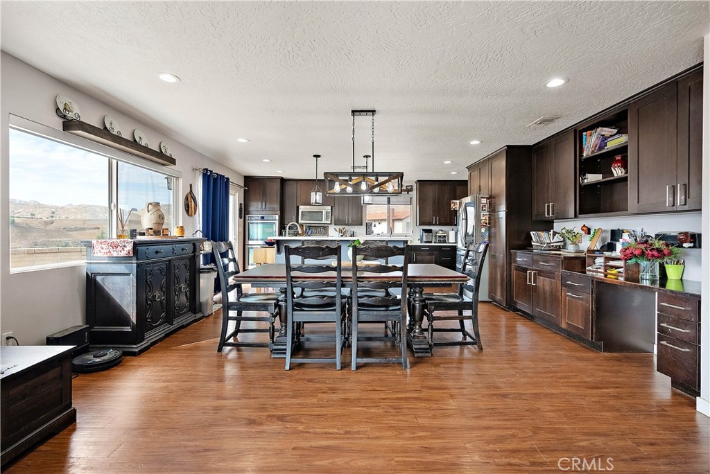 24444 Scotch Lane Colton, CA 92324 - Photo 11 of 43 a kitchen with stainless steel appliances a dining table chairs stove and a refrigerator