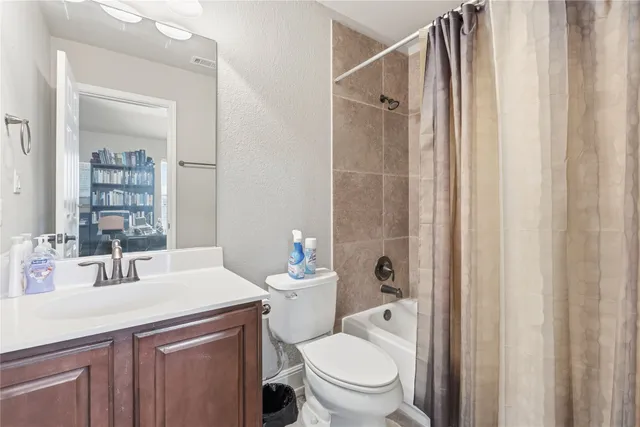 a bathroom with a sink a toilet and shower curtain