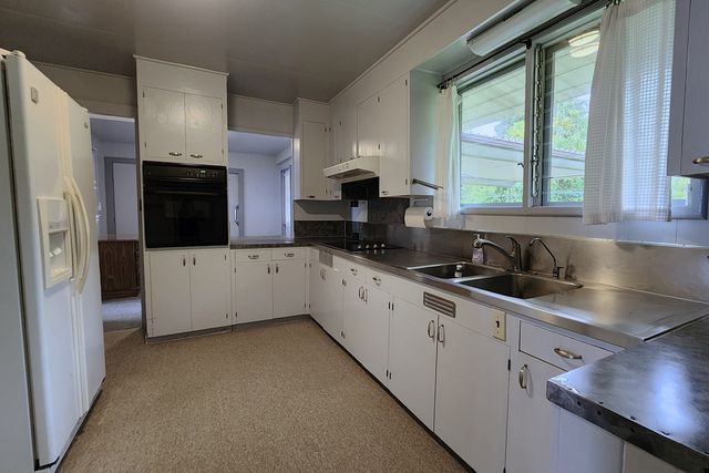 a kitchen with kitchen island a sink appliances and cabinets