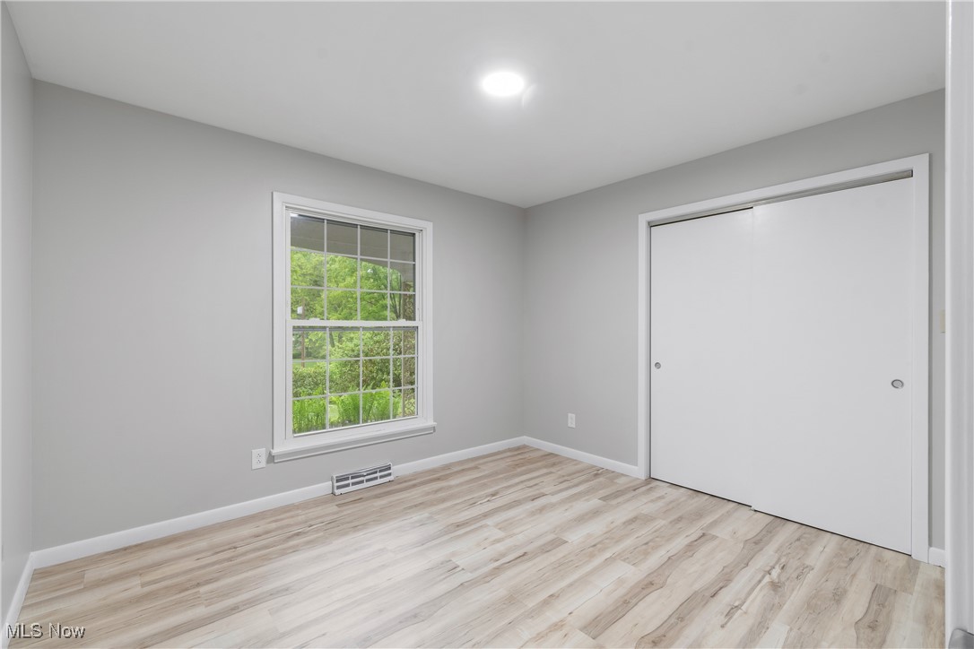 3143 Ethan Allen Road Barberton, OH 44203 - Photo 21 of 37 Unfurnished bedroom with light wood-type flooring and a closet