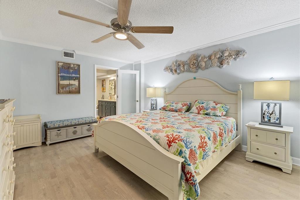 8776 Midnight Pass Road, Unit C107 Sarasota, FL 34242 - Photo 17 of 47 a bedroom with a large bed and a chandelier