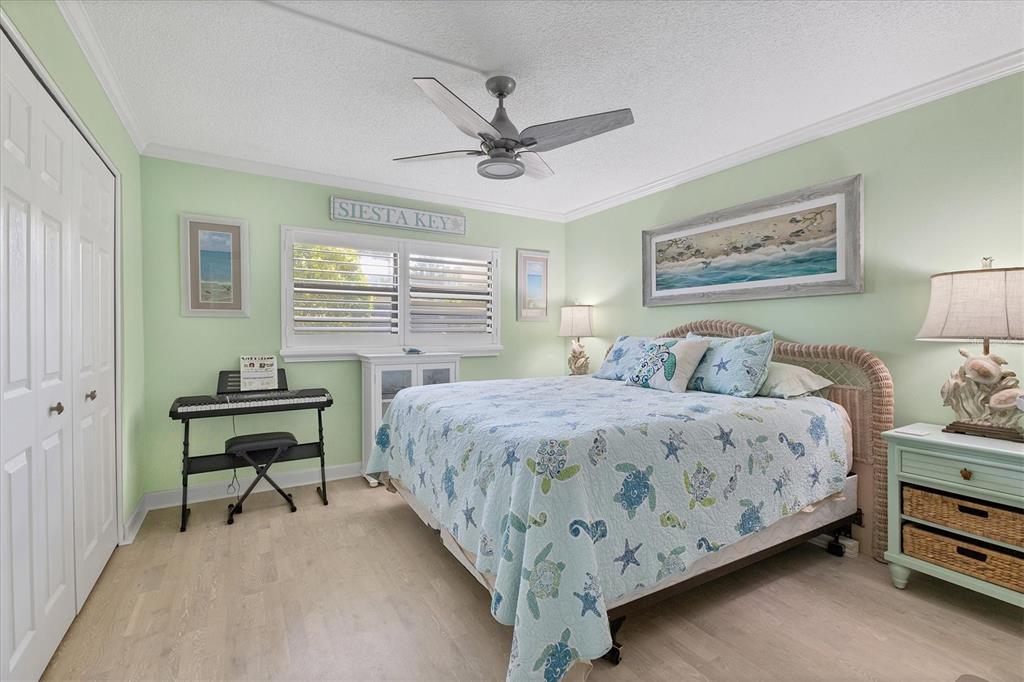8776 Midnight Pass Road, Unit C107 Sarasota, FL 34242 - Photo 21 of 47 a bedroom with a bed and a chandelier