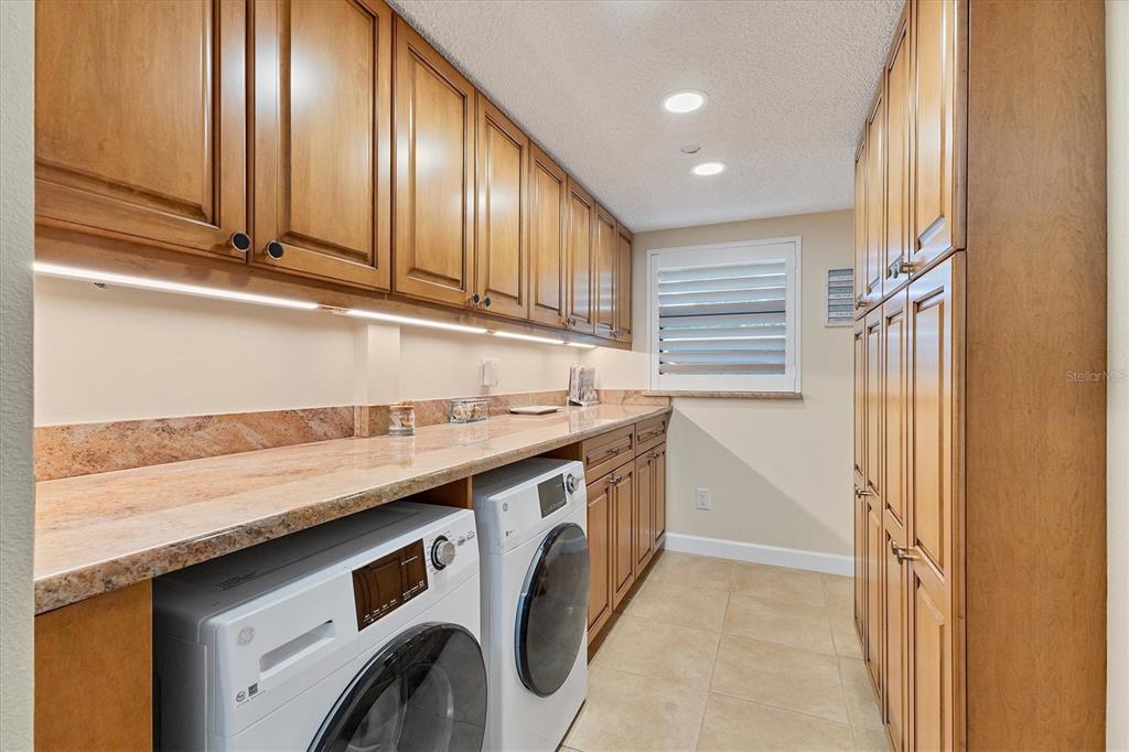 8776 Midnight Pass Road, Unit C107 Sarasota, FL 34242 - Photo 24 of 47 a utility room with stainless steel appliances granite countertop a sink and a refrigerator