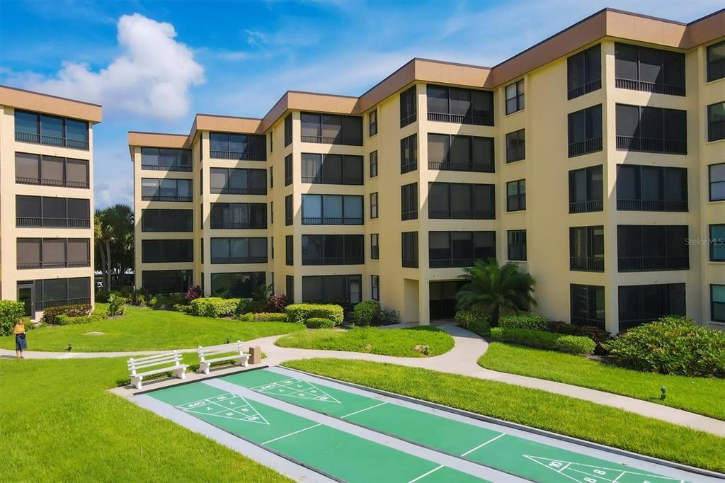 8776 Midnight Pass Road, Unit C107 Sarasota, FL 34242 - Photo 43 of 47 a view of a building with a yard