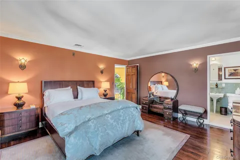 a bedroom with a bed a table and wooden floor