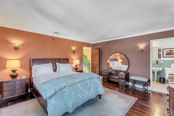 a bedroom with a bed a table and wooden floor