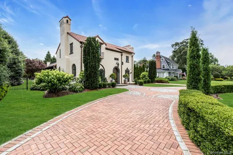 a front view of a house with a yard and potted plants