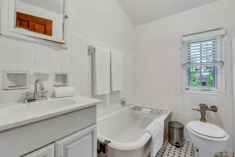 a bathroom with a toilet sink and mirror