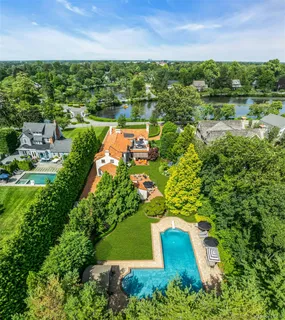 an aerial view of residential houses with outdoor space and trees all around