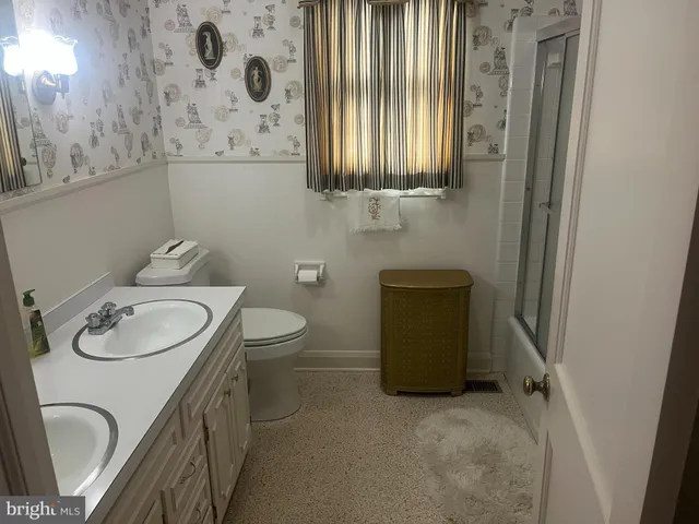 a bathroom with a toilet a sink and mirror
