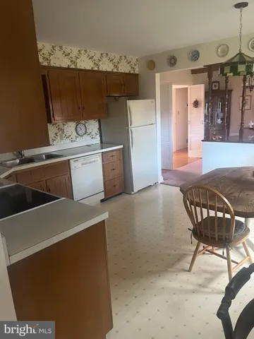 a view of kitchen with furniture and refrigerator