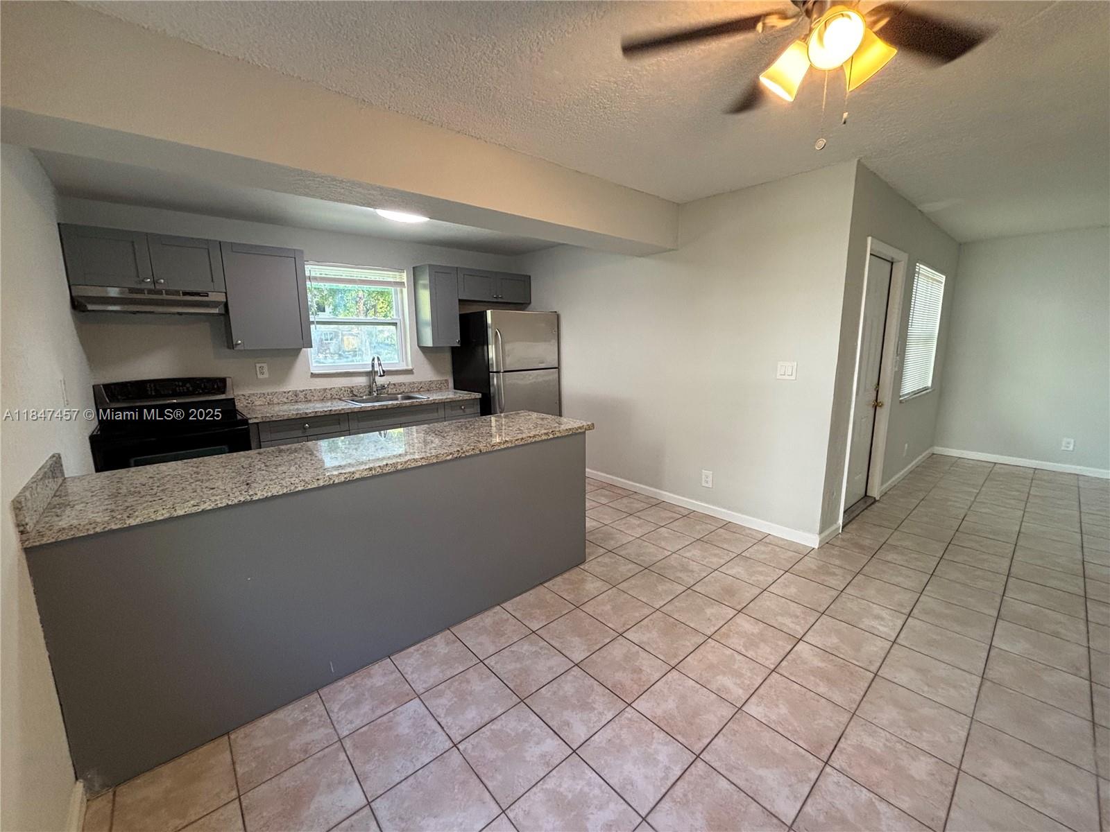 7921 Northwest 44th Court, Unit 2 Coral Springs, FL 33065 - Photo 2 of 11 a kitchen with a sink a window and cabinets