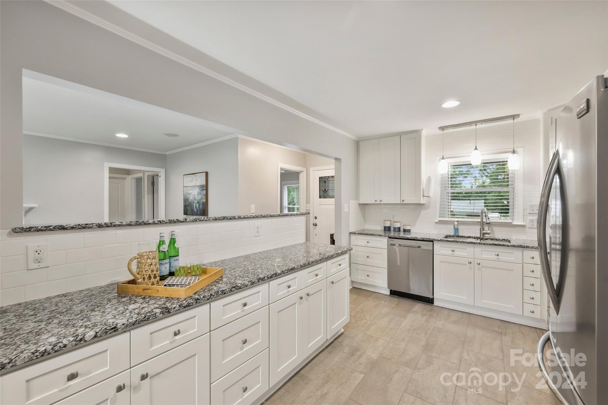 515 Bartling Road Charlotte, NC 28209 - Photo 14 of 42 a large white kitchen with granite countertop a sink white cabinets and stainless steel appliances