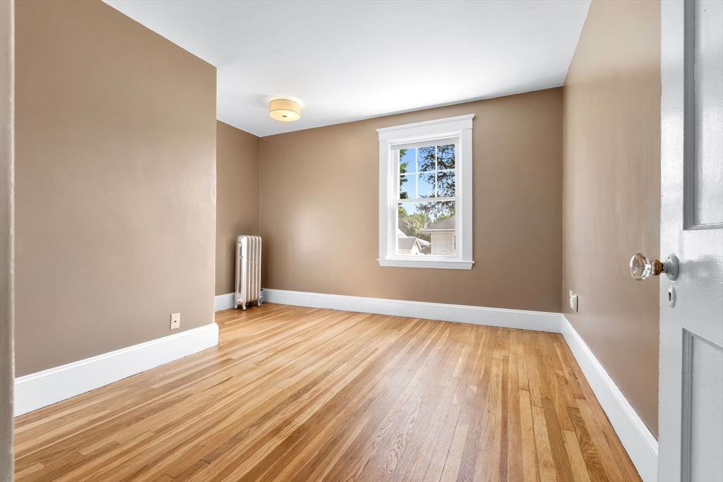 17 Coolidge Street Stoneham, MA 02180 - Photo 31 of 37 wooden floor in an empty room with a window